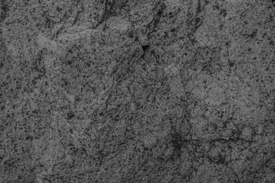 Close up of grey granite surface texture background. Intrusive igneous rock
