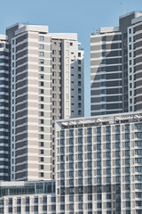 Fototapeta premium Cluster of modern residential towers under clear sky in city district