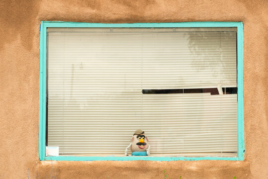 USA, New Mexico, Rancho de Taos. A plastic toy in residential window.