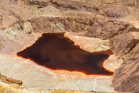 USA, Arizona,  Cochise County, Bisbee.  Water at the bottom of the open pit of the Copper Queen Mine.   The reddish color of the water is a result of iron oxidization, resulting in acid mine drainage.