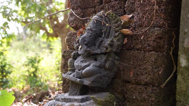 Ancient Ganesh idol in jungle, Karwar, Karnat.aka. Lord Ganesha statue in ruins surrounded by forest