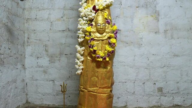 Close up of golden Shivling inside Hindu temple in Karnataka India, showcasing sacred Shiva lingam with spiritual atmosphere and religious significance