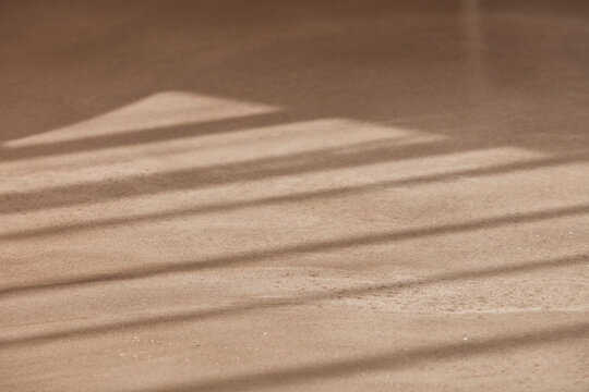 Long dramatic sunlight shadows across warm wood floor