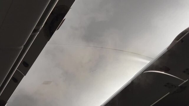 Cold mist forming from chilled air circulating through overhead vents inside an airplane cabin.