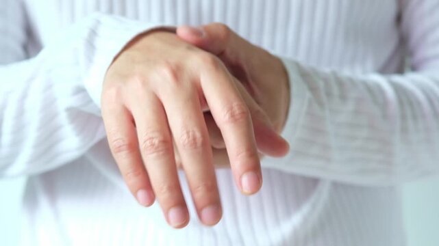Man holding his hand suffering from finger joint pain or numbness; concept of arthritis, carpal tunnel syndrome, gout and trigger finger from work and office syndrome medical concept