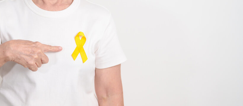 Elderly with Yellow Ribbon for concept of yellow September, Suicide prevention day, Childhood, July Sarcoma, bone and bladder cancer Awareness month, support survivor. Healthcare and World Cancer day