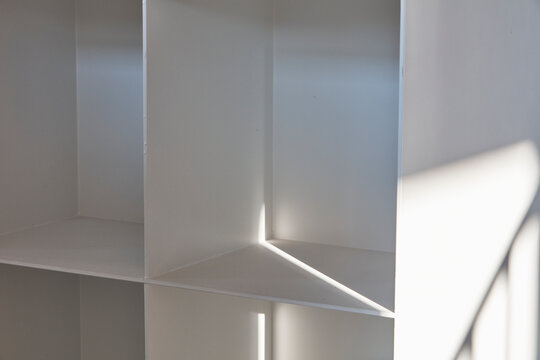 White built in cubbies with strong sunlight and graphic shadows