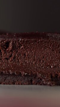 Close-up slow motion of moist chocolate brownie as a spoon glides through soft texture. Rich fudgy interior and dense chocolate crumb, dessert and indulgent food concept.