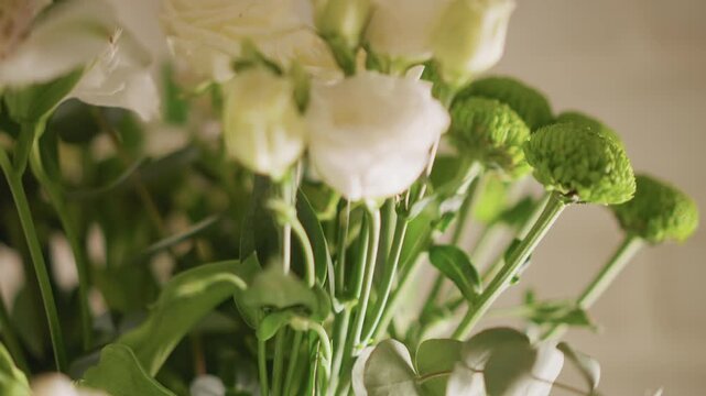 Closeup home bouquet white and green stems in soft natural light, delicate lisianthus and button chrysanthemums, shallow depth of field, intimate still life, florist arranging, table vignette, warm