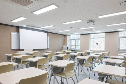 Modern classroom with yellow chairs and projection screen in academic interior