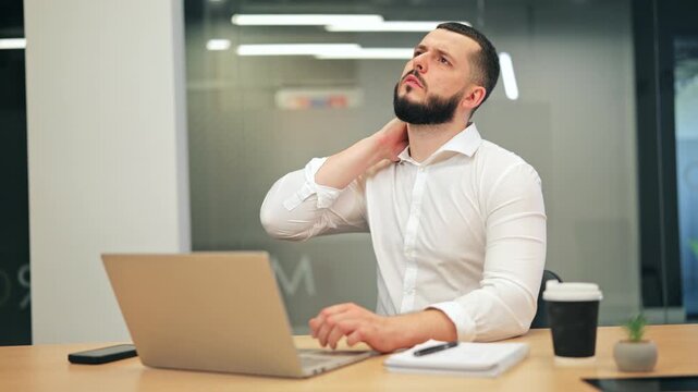 Office worker experiences noticeable neck pain while typing. Discomfort and frustration visible during extended laptop use, highlighting physical strain of prolonged screen time, sustained effort.