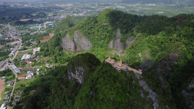 Drone swoop over Tiger Cave Temple showing its position along a narrow ridge, with expansive views of the valley and surrounding environment.