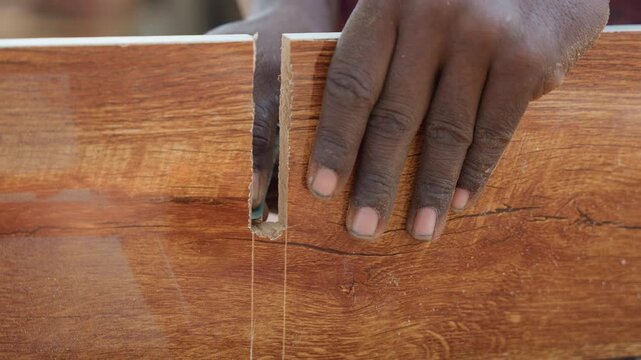 Black carpenter chiseling mortise in hardwood plank, measuring and marking layout then cutting deep rectangular slot, closeup darkskinned hands guiding chisel with steady pressure, woodgrain dust