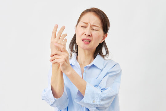 白背景で手の痛みに悩む女性