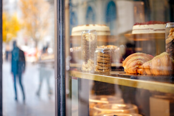 Fototapeta premium Pastry in a shop window, defocused man walking away