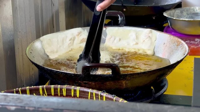 Cooking the Indonesian street food (Cempedak fritters) in a pan