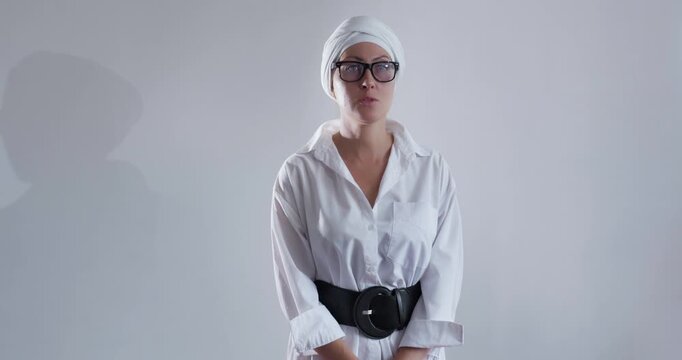 Business goal-oriented young woman in glasses and turban thought. Front view