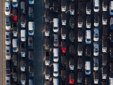 Top down new car lot with perfectly aligned rows of vehicles