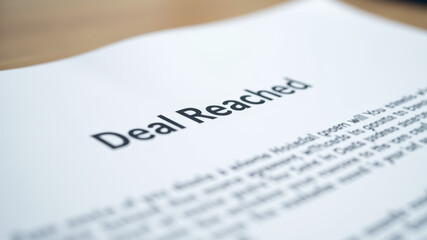 Fototapeta premium Official paper titled deal reached symbolizing successful negotiation agreement closure and resolution in business or politics