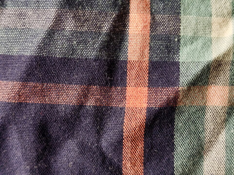Textura de tela de algod&oacute;n con patr&oacute;n de cuadros escoceses en colores naranja, azul y verde con pliegues naturales