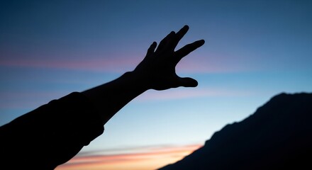Obraz premium human hand silhouette reaching towards vibrant sunset sky and mountain landscape