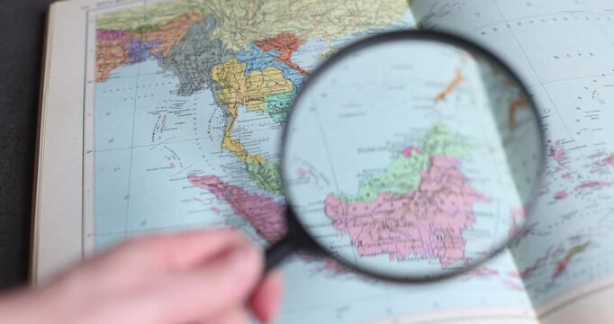 Magnifying glass focusing on Russia and Europe on vintage world map, close up. Magnifying glass, Russia, Europe, world map, focusing, vintage, close up
