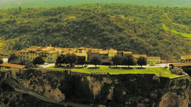 Vista a&eacute;rea cinematogr&aacute;fica del conjunto medieval de Fr&iacute;as, capturada con dron durante la hora dorada. El imponente Castillo de Fr&iacute;as se alza sobre un escarpado risco, dominando el paisaje con su arqu