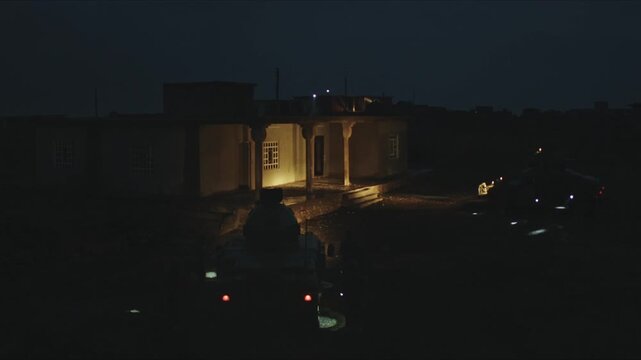 Special operations forces conducting a covert night mission, approaching a building during a raid