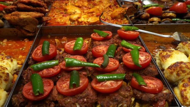 Variety of authentic Turkish food displayed at a traditional lokanta or bistro in Istanbul. Wide selection of ready-to-eat dishes like kebabs, stews, vegetables, and casseroles for lunch.