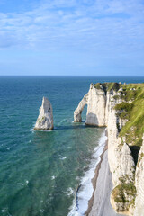 Obraz premium Vertical view of Etretat Aiguille needle rock and chalk arch with wind turbines Normandy