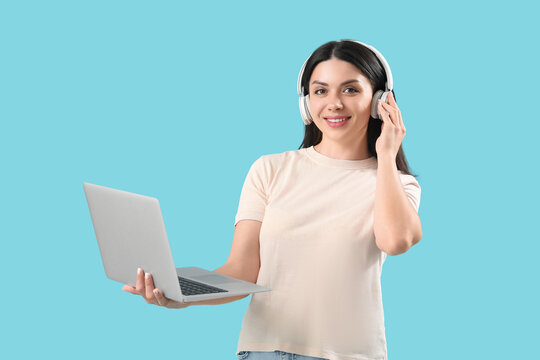 Female programmer in headphones with laptop on blue background