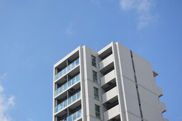 Obraz premium 澄み渡る青空の下に建つ白い集合住宅