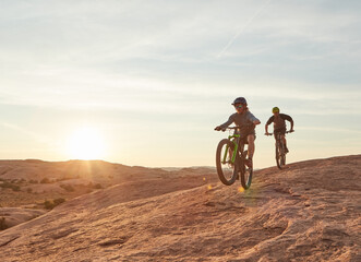 Obraz premium Friends, cycling and adventure in nature with mountain bike, action and training together for fitness. Space, people and countryside journey with bicycle, sunshine and outdoor exercise for wellness.