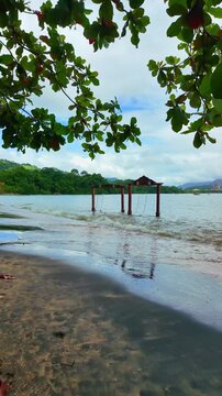 Walking on Pantai Pasir Hitam beach, also called Black Sand beach in Langkawi, Malaysia