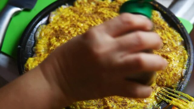 Raw chicken breast being seasoned and prepared for cooking.