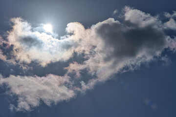 Obraz premium Iridescent clouds with bright sun in the blue sky