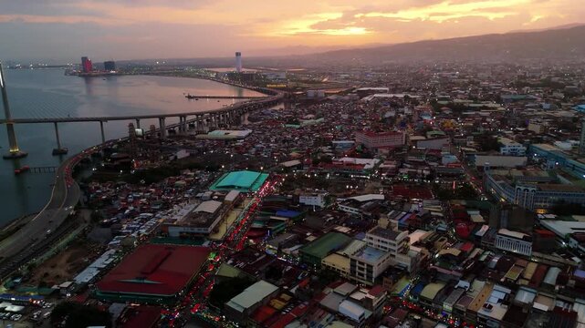 aerial drone sunset view of bustling metropolis of Cebu City, Philippines, during twilight with vibrant city lights turning on