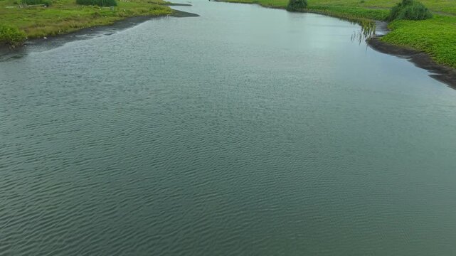 Aerial view of the Opak River winding through lush green landscapes, showcasing the natural beauty of the region, Bantul Regency, Daerah Istimewa Yogyakarta, Indonesia.