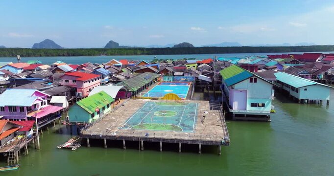 Aerial View Of Koh Panyee Floating Village In Thailand, With Stilted Football Pitch Surrounded By Colorful Houses. ascending forward shot