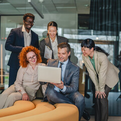 Obraz premium Diverse business team collaborating and discussing project on laptop