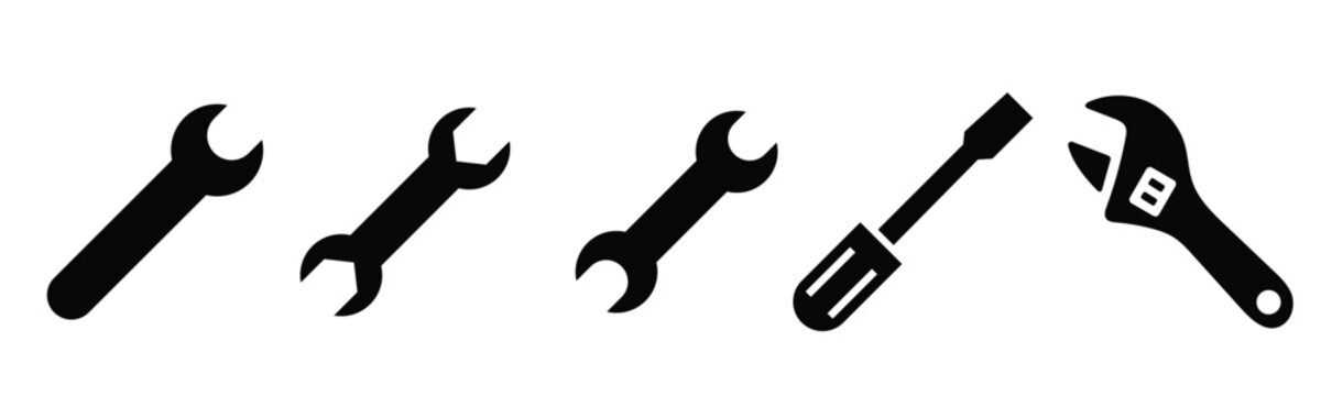 Black silhouette vector icons of essential mechanic hand tools a set of open-end wrenches a flathead screwdriver and an adjustable spanner