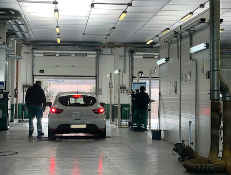 Coche pasando ITV con mec&aacute;nicos de Inspecci&oacute;n T&eacute;cnica de Veh&iacute;culos