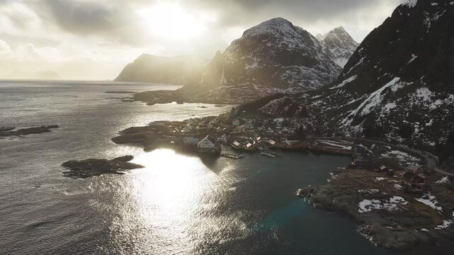 Aerial view of the picturesque Tind village nestled between the tranquil sea and snow-dusted mountains, Nordland, Tind, Norway.