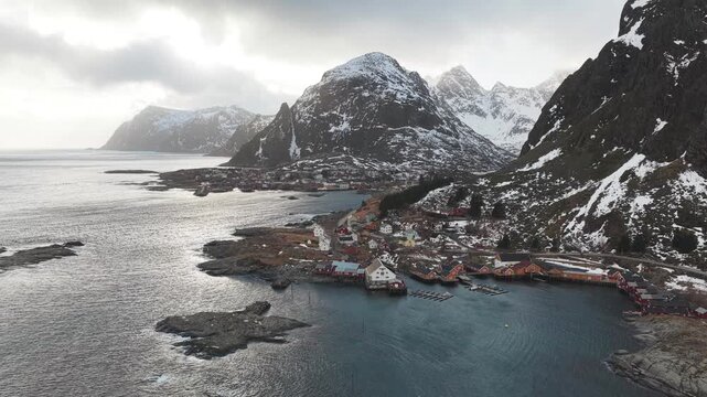 Aerial view of the tranquil Tind village nestled amidst majestic mountains meeting the serene waters, creating a stunning contrast of textures, Tind, Nordland, Norway.