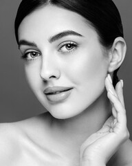 Portrait beautiful young woman with clean fresh skin. Model with healthy skin looks at an empty space, close up portrait. Cosmetology, beauty and spa