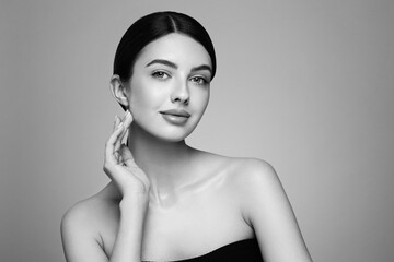 Portrait beautiful young woman with clean fresh skin. Model with healthy skin looks at an empty space, close up portrait. Cosmetology, beauty and spa