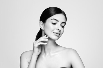 Portrait beautiful young woman with clean fresh skin. Model with healthy skin looks at an empty space, close up portrait. Cosmetology, beauty and spa