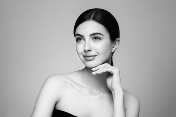 Portrait beautiful young woman with clean fresh skin. Model with healthy skin looks at an empty space, close up portrait. Cosmetology, beauty and spa