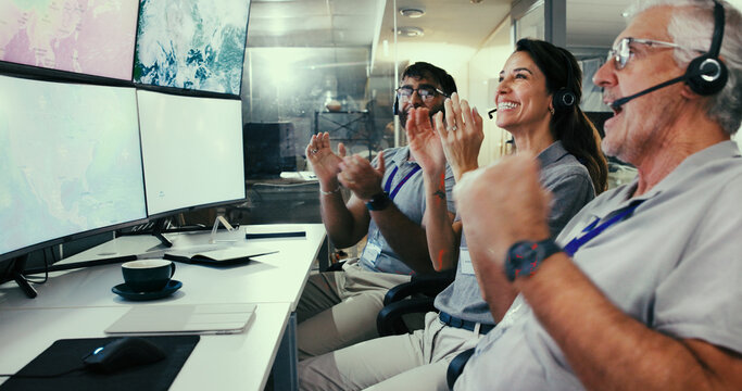 Applause, computer and satellite with people in control room for team, launch success and mission target. Collaboration, aeronautic engineer and achievement with employees clapping for monitor