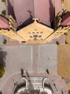 Aerial view of St. Patrick's Cathedral featuring its red rooftops and stone facade with a cross shadow on the courtyard in Karachi, Sindh, Pakistan.